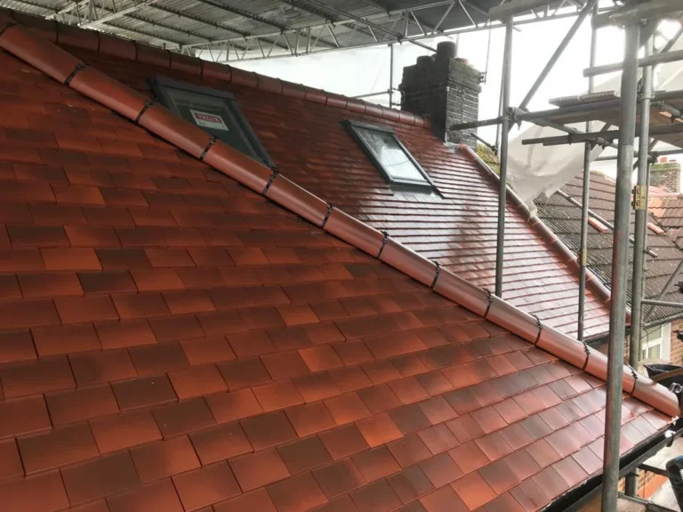A newly tiled roofing with a skylight and gutter system, viewed from scaffolding. Loft Conversions, House Extensions, Roofing, Bespoke Loft Conversions, House Renovations