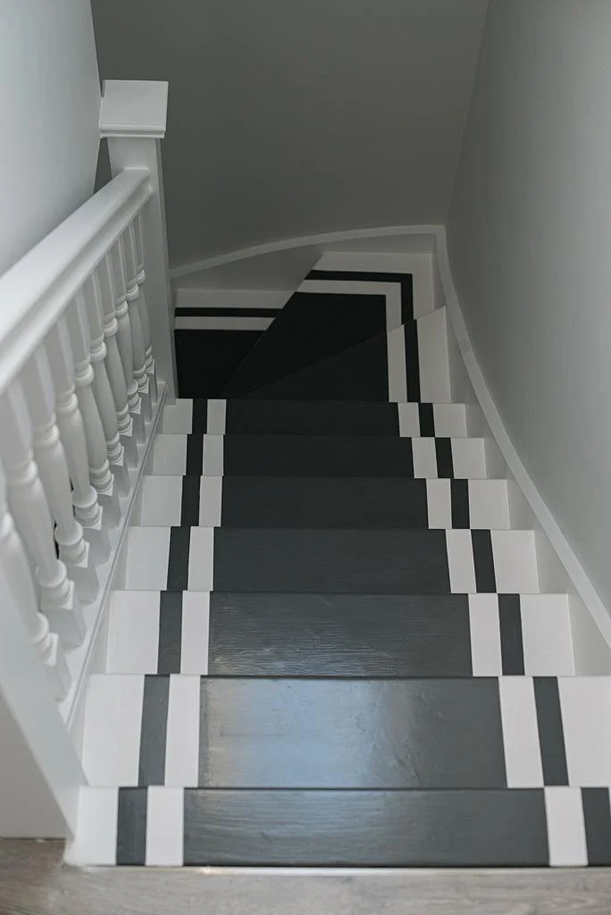 A staircase with a black and white checkered pattern on the steps, leading to a basement refurbishment, viewed from the top landing. Loft Conversions, House Extensions, Roofing, Bespoke Loft Conversions, House Renovations